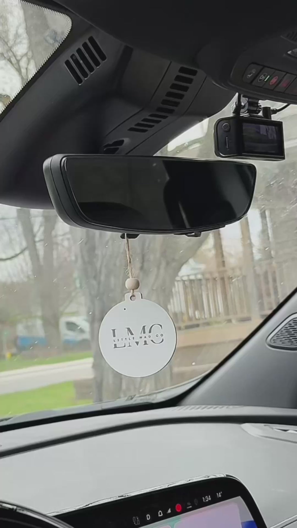 Personalized photo ornament hanging from a car rearview mirror